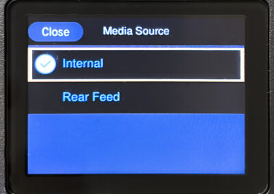 Media Source menu on screen with Internal option selected, Rear Feed option, and Close button at top left corner.