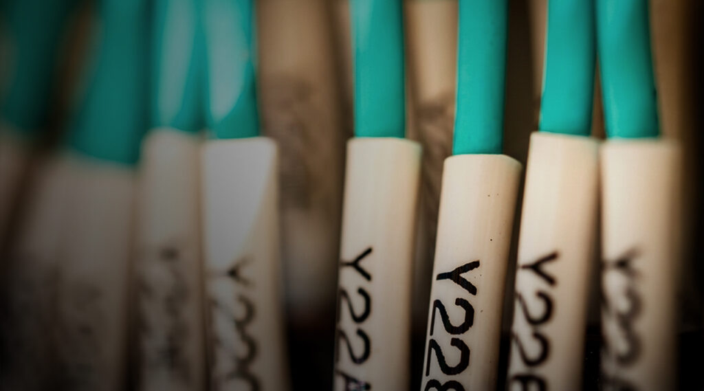 Close-up of white-handled tools labeled Y228 in black with turquoise tops, arranged together, shallow depth of field, high detail.