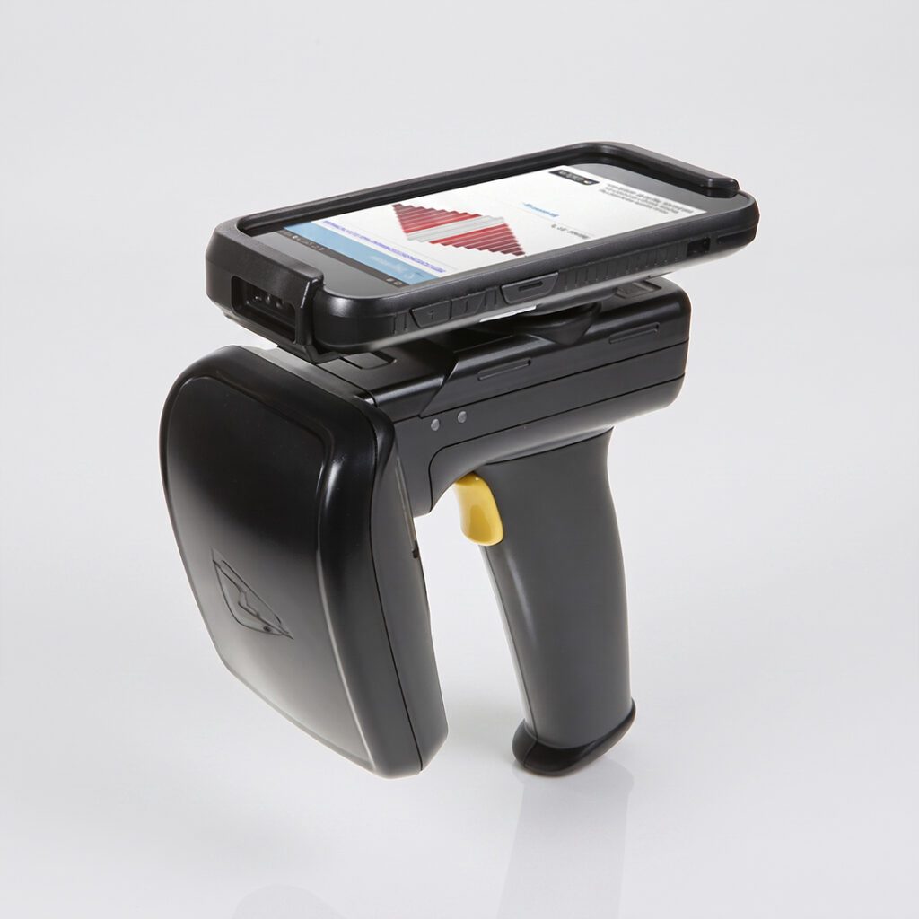 Handheld barcode scanner with touchscreen showing a chart, black body, yellow trigger, on a white background.