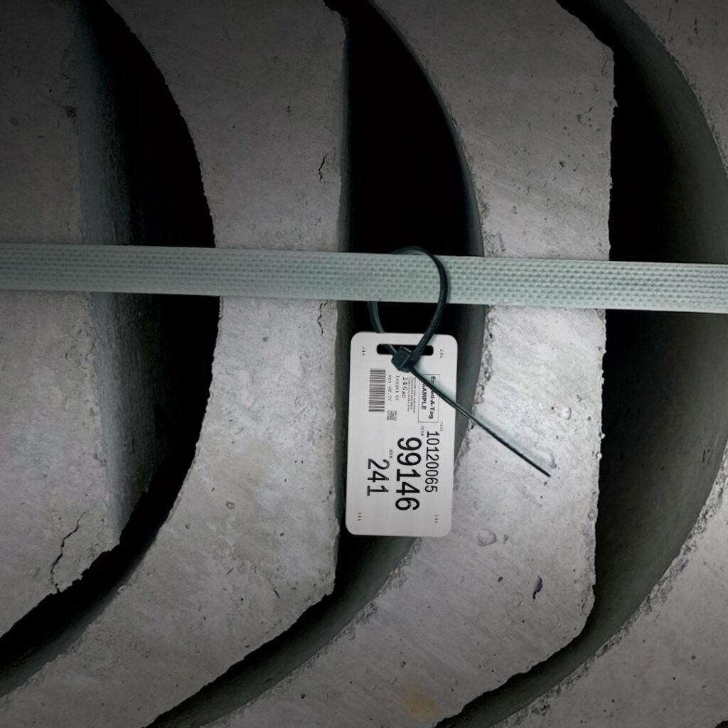 Curved concrete slabs stacked with a blue strap and central white barcode tag labeled 10200865 9246 241.