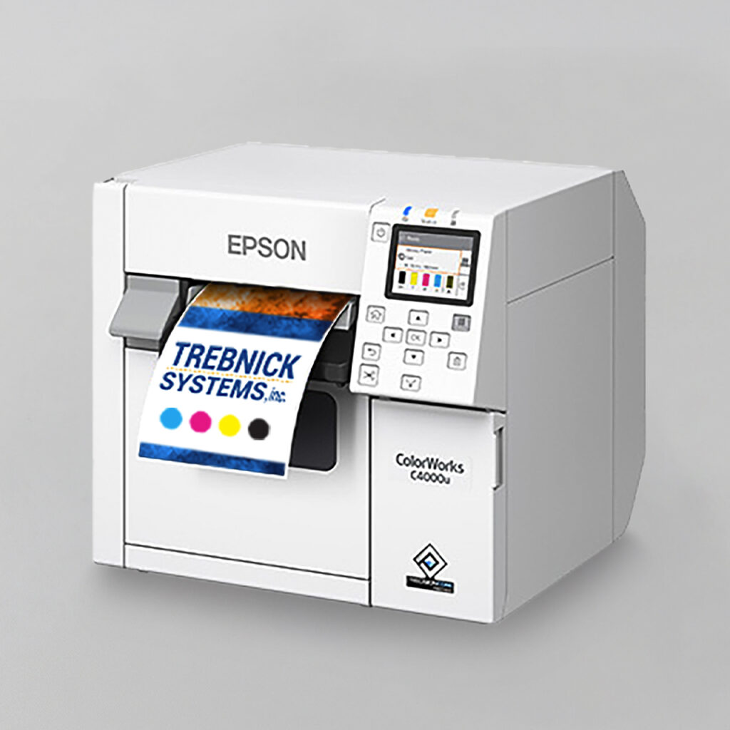White Epson ColorWorks label printer printing a TREBNICK SYSTEMS, INC. label with CMYK color dots, small display, and control buttons.