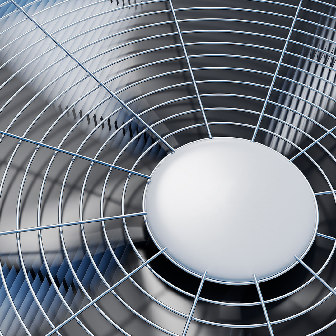 Close-up view of the protective metal grill covering the top of an outdoor air conditioning unit, with reflections visible on the metallic surface.