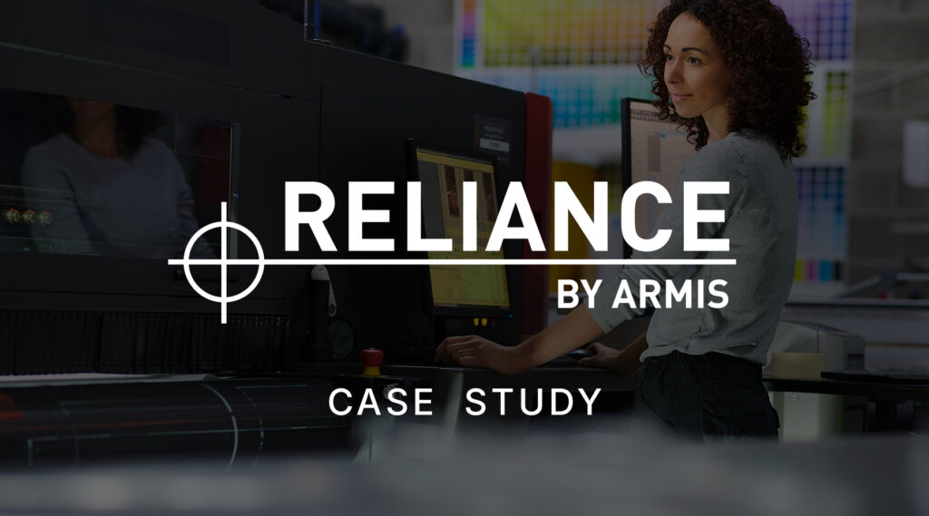 Woman standing in front of a desktop computer, looking at the screen in a modern office environment.