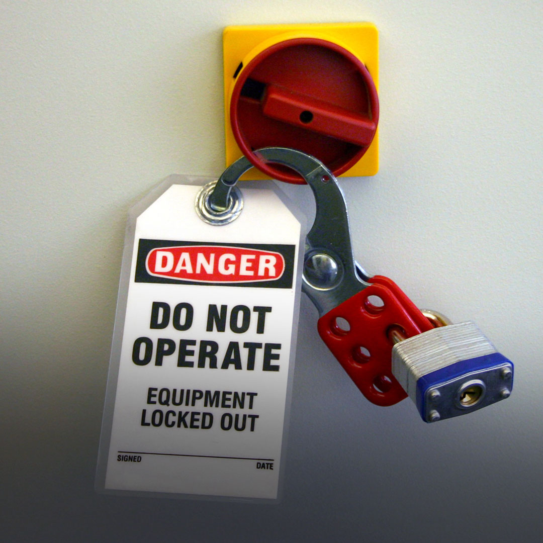 Red lockout device with padlock and danger tag warning not to operate, securely attached to an electrical control switch.