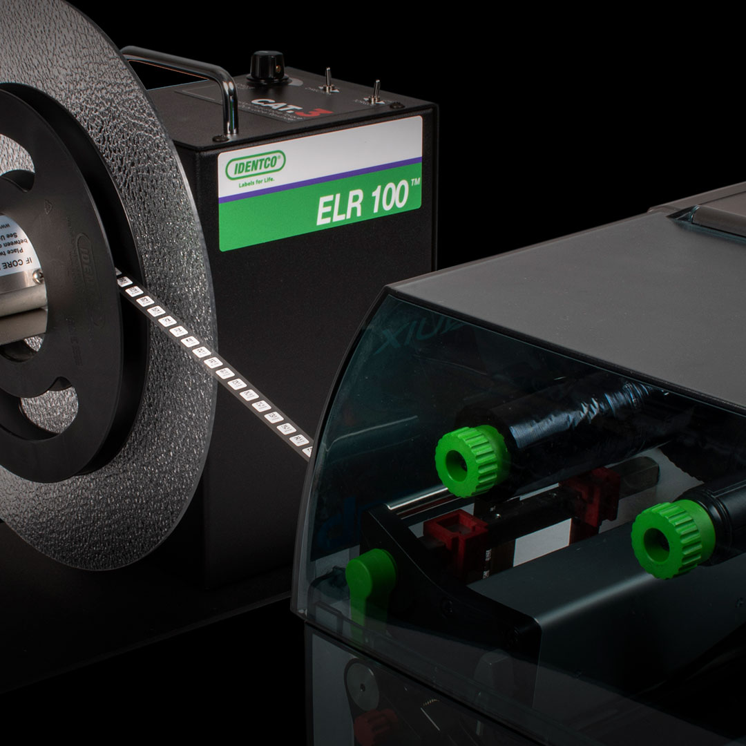 ELR 100 reel-to-reel label applicator with partially loaded label roll feeding into printer, showing green rollers and components.
