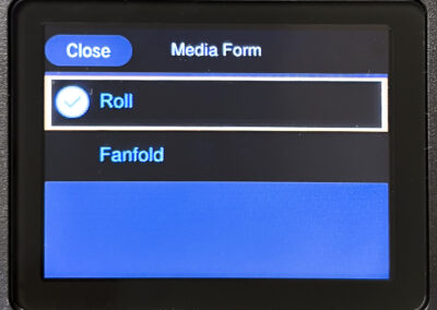 Digital screen showing media form options with Roll selected, Fanfold available, and a Close button in the top left corner.