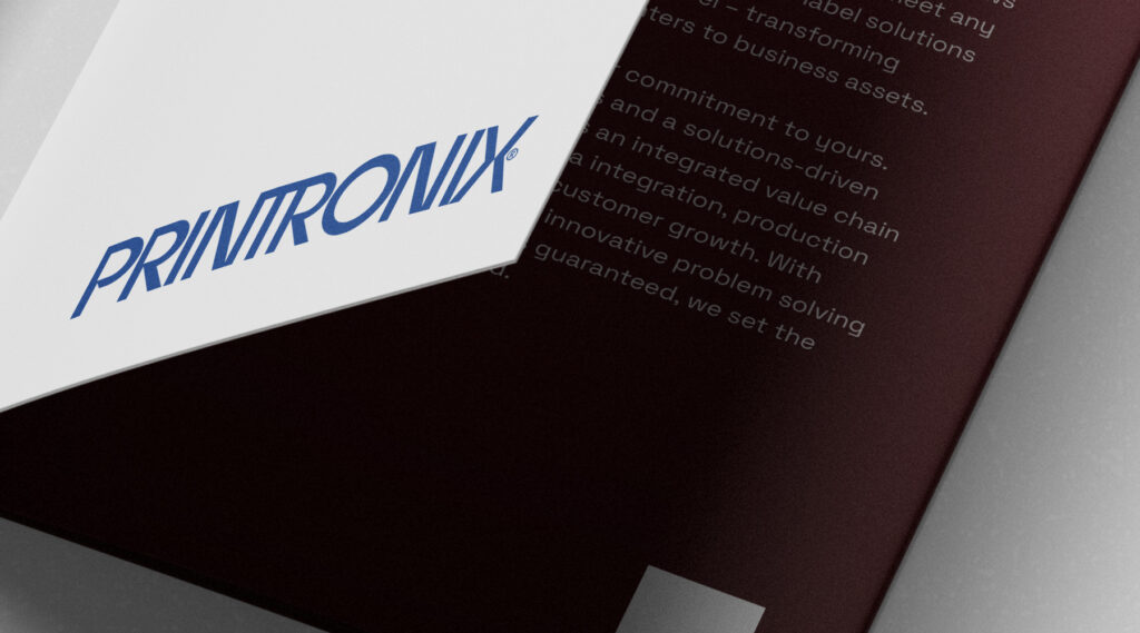 Close-up of a partially opened folder with PRINTROVIX blue logo on white cover and white text on maroon inner page.