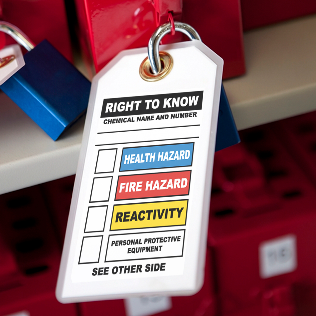 Close-up of a Right to Know chemical safety tag showing health, fire, and reactivity ratings on a red container with blue padlock.