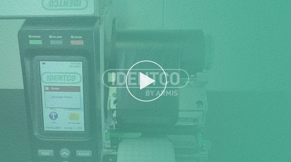 IDENTCO label printer showing error message on display, overlaid with transparent green and centered play button icon.