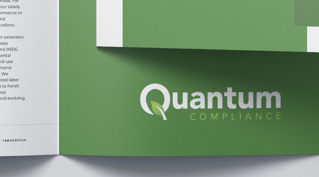 Green folder with Quantum Compliance logo in white and light green, leaf forms Q; partial open document visible on the left.