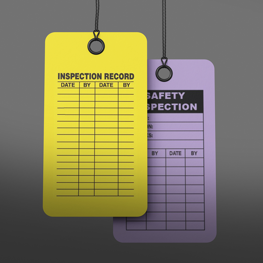 Yellow Inspection Record tag with blank date and signature columns, front; purple Safety Inspection tag partially visible behind, gray background.