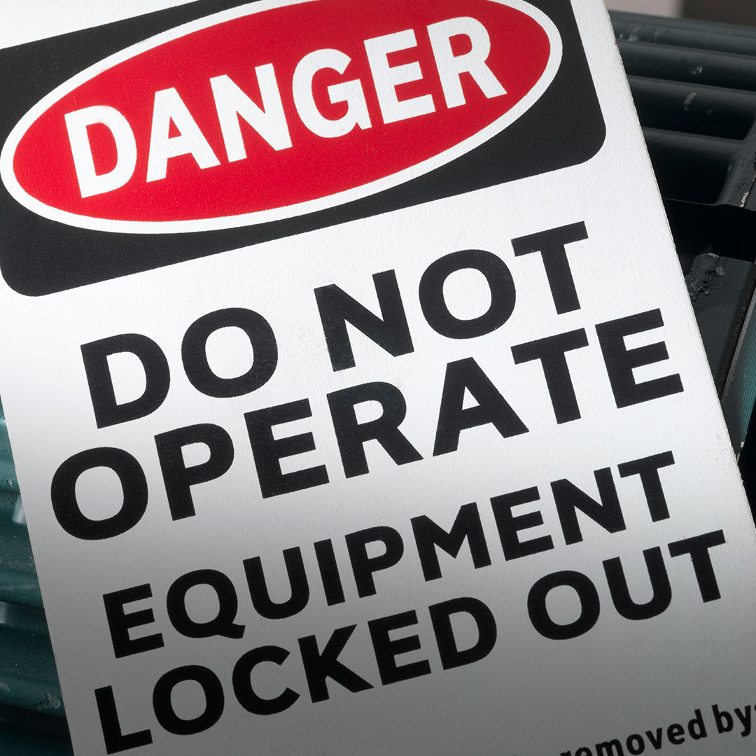 Warning sign with bold text on white background, red DANGER label, and message: DO NOT OPERATE. EQUIPMENT LOCKED OUT.