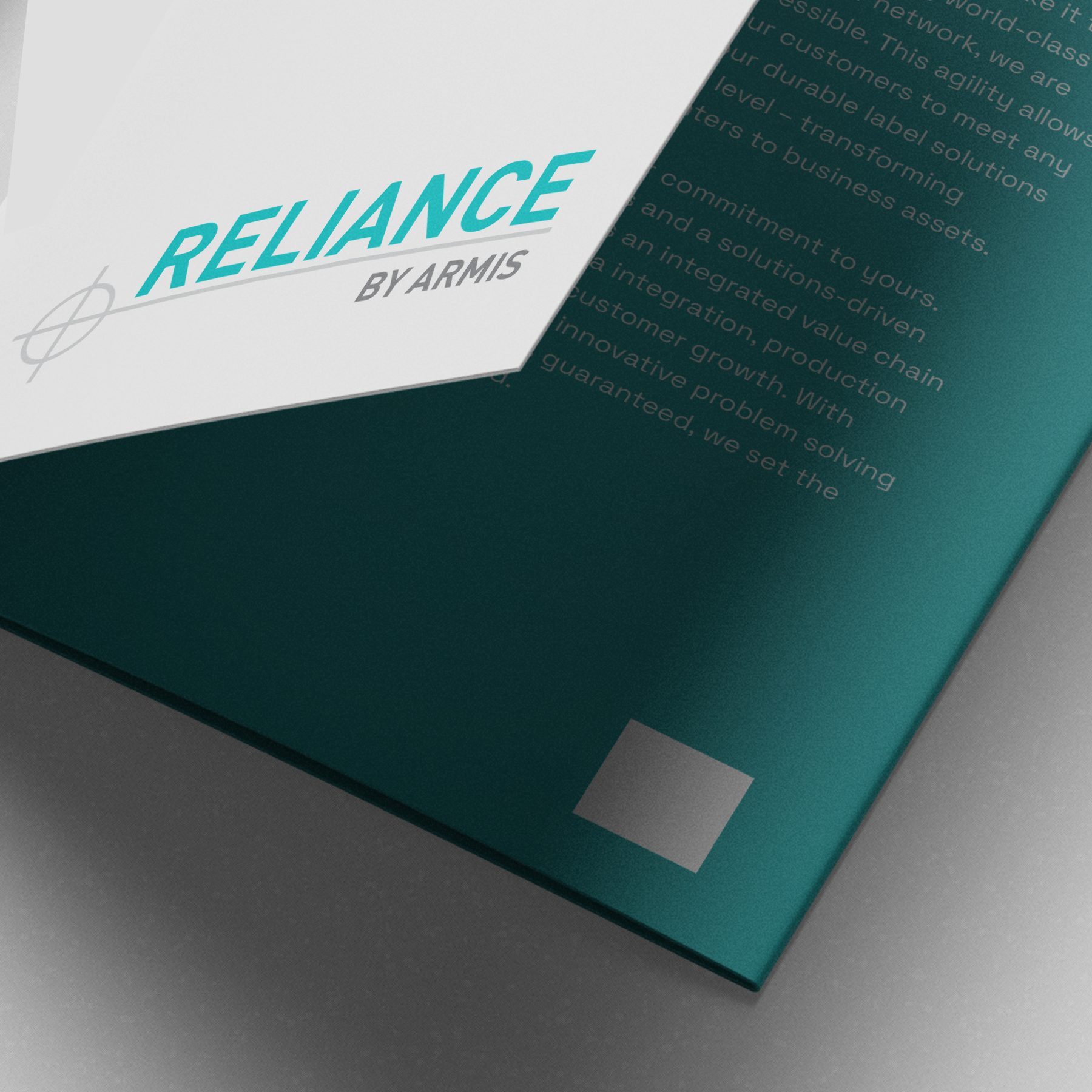 Close-up of teal and white Reliance by Armis brochure with modern typography, minimalist geometric design, partial business text.