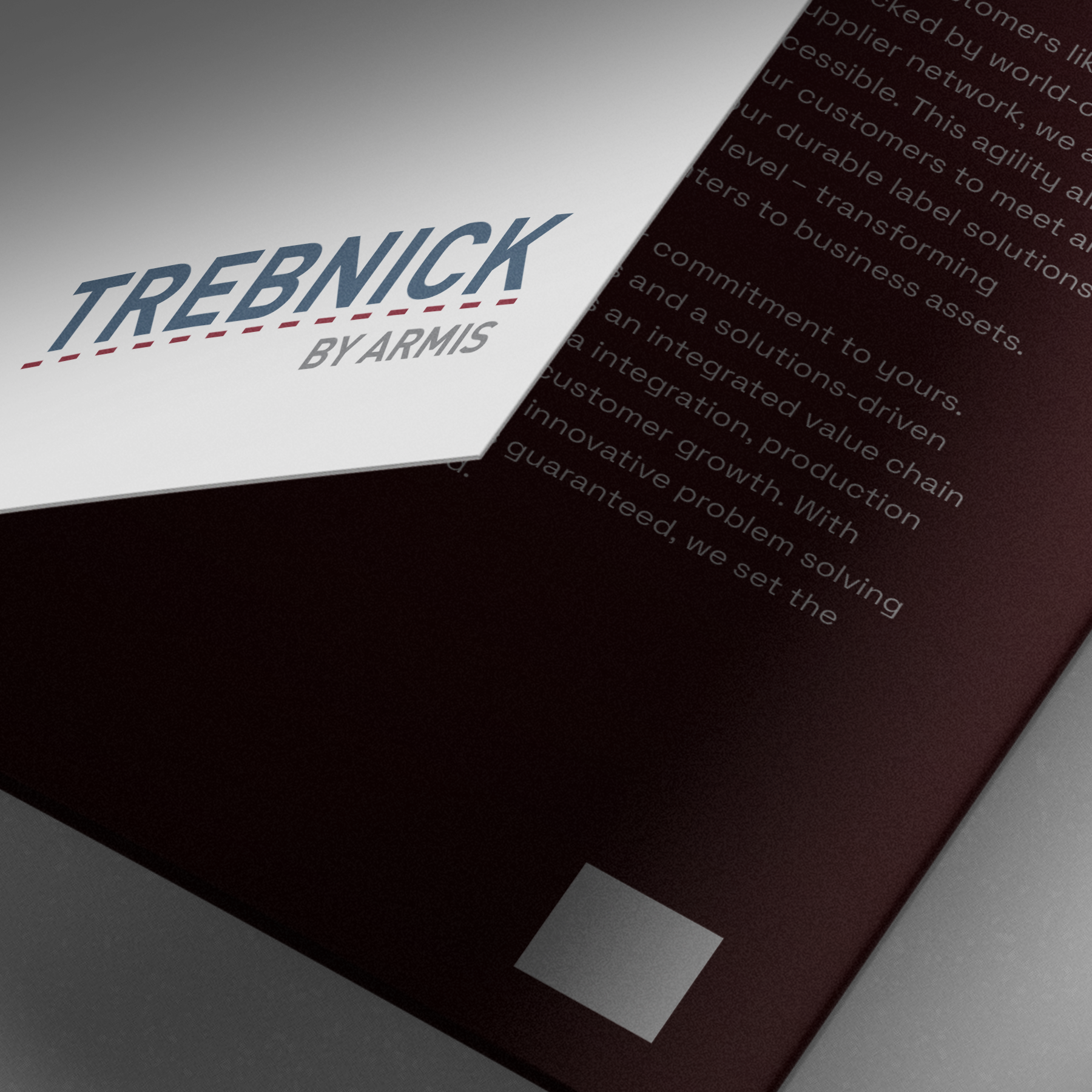 Close-up of TREBNICK BY ARMIS brochure cover in bold letters with blurred white text on a dark background partially visible.