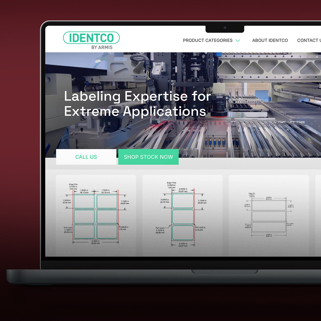 Laptop showing IDENTCO website with industrial machinery, navigation menus, label templates, and labeling expertise headline.