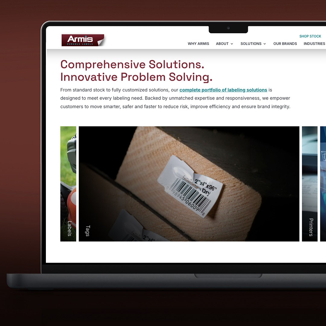Laptop displaying Armis website with details on labeling solutions and a close-up of a barcode label on a cardboard box.